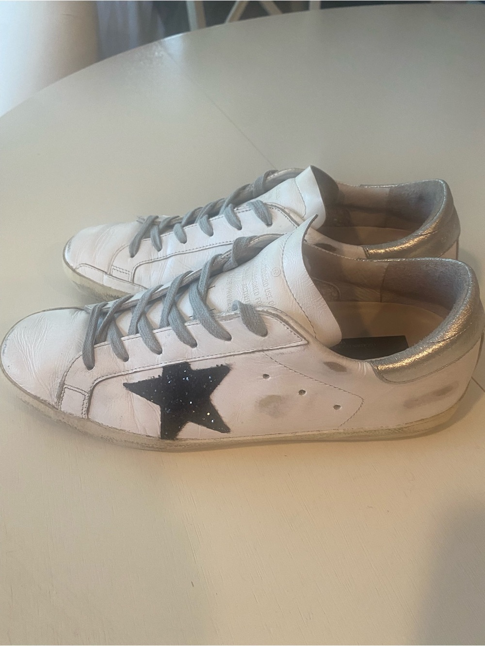 Golden Goose Superstar distressed white sneakerswith the black star and silver